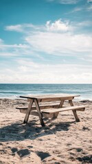 A wooden table sits on the edge of a sandy beach, perfect for outdoor gatherings or a unique picnic spot