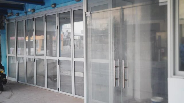 Abandoned or closed store or retail shop or restaurant in main street. Out of business or foreclosed. Touristic area or boardwalk. Financial crisis or market crash. Glass doors with empty rooms