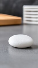 Smooth white stone on gray surface in minimalist setting