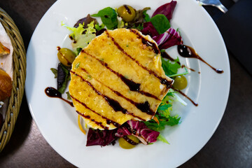 Image of scallop baked with cheese in seashells, served with lettuce and balsamic
