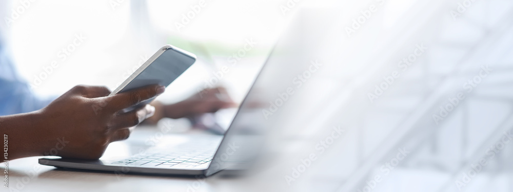 Poster unrecognizable black woman using smartphone and working on laptop in white office, checking new mobi