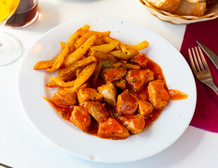 Delicious stewed pork in tomato sauce served on plate with potatoe