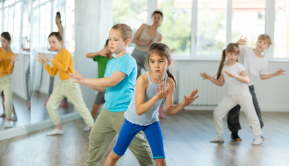 Naklejka premium Group of children boys and girls dance energetic pair dance twist in studio