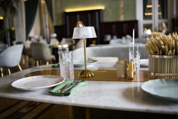 modern table setting in a trendy restaurant. Sofa, armchair, table and dishes on the table