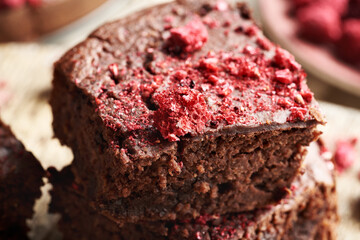 Pieces of homemade gluten-free brownies made with red kidney beans, oat flakes, chocolate and freeze-dried raspberries