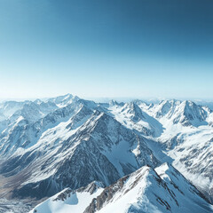 Naklejka premium Aerial view of snow covered mountain range under a clear blue sky in a high altitude landscape