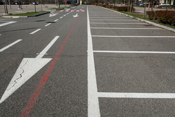 road signs with mandatory direction arrows and parking space lines. symbols on asphalt are dictated by the highway code. road design starts with the study of mobility, frequency and travel data.