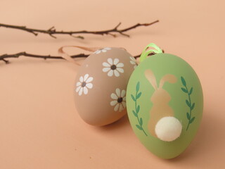 Decorated Easter eggs and dried branches on salmon background.