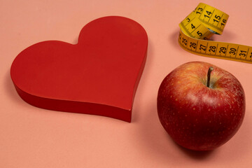 Heart shape with an apple and measuring tape, concept of heart problem and overweight
