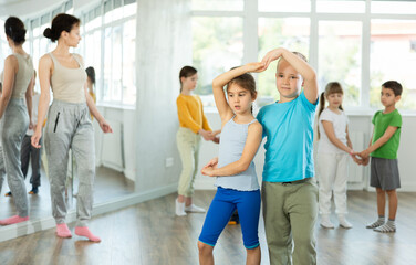 Fototapeta premium Children bachata dance group lesson in studio .Club for those who like to dance for their own pleasure, non-professional dance performers enjoy slow pair dance during rehearsal in studio