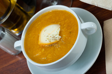 Plate of low calorie pumpkin and carrot puree served with cheese and herbs