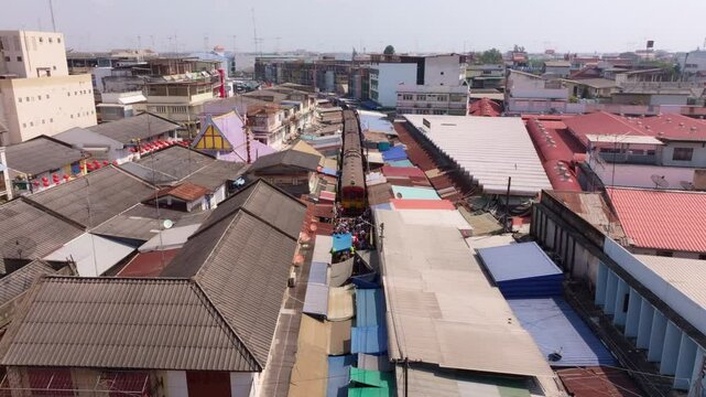 Timelapse of Maeklong Railway Market with locals and trains, Thailand. Aerial drone video