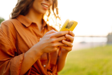 Hands of woman holding smartphone, using online app and virtual services cellphone, making video phone call, texting and chatting on messengers, buying online. Blogging. Close up