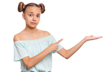 A young girl with playful hairstyle pointing to the side with a confused expression.