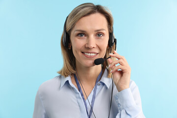 Technical support call center. Portrait of smiling operator on light blue background