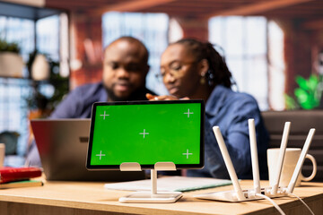 African American couple browse troubleshooting online guide next to chroma key, working together to...