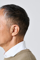 Obraz premium 私服姿のシニア男性の耳元