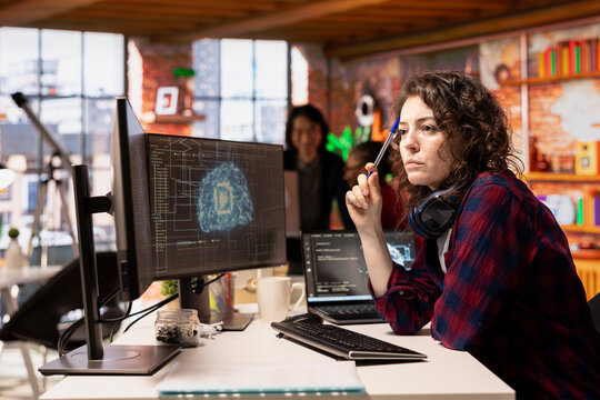 Woman working in AI tech agency providing custom software development services. IT expert using artificial intelligence technology to streamline coding process in innovative startup office