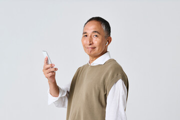 スマートフォンで音楽を聴く私服姿のシニア男性