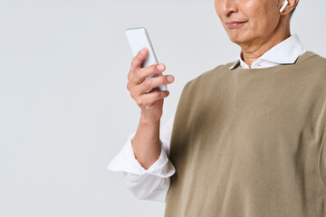 スマートフォンを使う私服姿のシニア男性の手元
