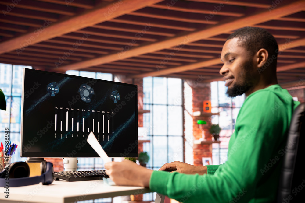 Poster smiling man in home office using financial application ui on pc screen showing company revenue and e