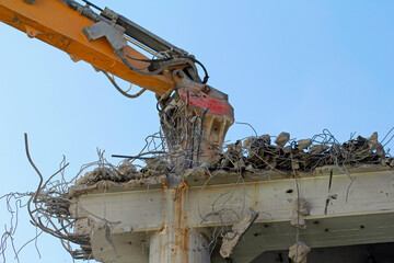 demolition work with excavator and blue sky
