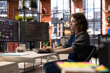Software developer at agency office coding on her computer creating a software and works on implementing algorithms. IT expert building applications with a programming interface.