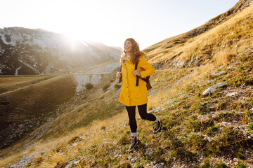 Obraz premium Woman tourist standing at mountains with backpack admiring landscape. Exploring wilderness in National Park. Travel, hiking concept