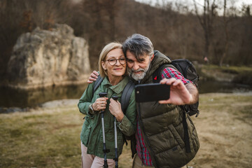 Fototapeta premium happy couple hiker backpacker explore forest and take self portrait
