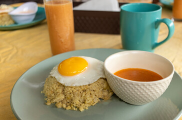 Traditional Ecuadorian breakfast from the coastal region: mashed green plantain with mature cheese and a fried egg with meat sauce, coffee, and guava juice