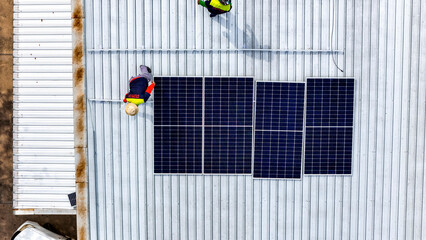 A sustainable energy project featuring solar panels on a roof surrounded by tropical trees, highlighting renewable energy efforts and the integration of green technology into rural areas.