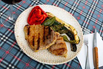 Nicely served plate of tasty beef steak with baked tomatoes eggplant and chili peppers
