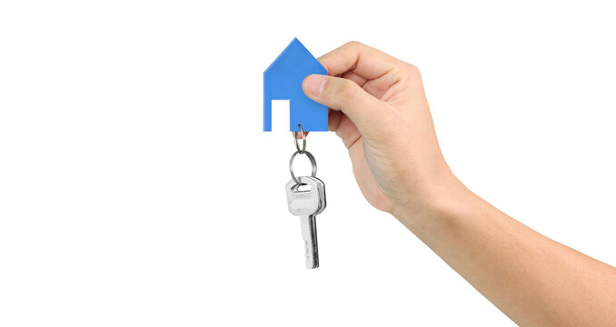 Hand holding house key and blue paper house symbolizing new home ownership indoor setting real estate concept close-up view for seo impact