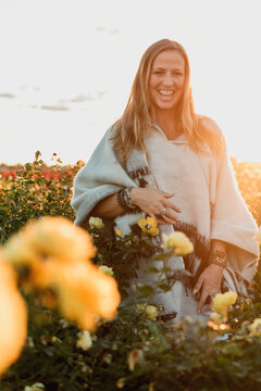 Woman smiling in a field of yellow roses