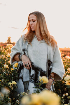 Profile of woman in rose field wearing a pancho