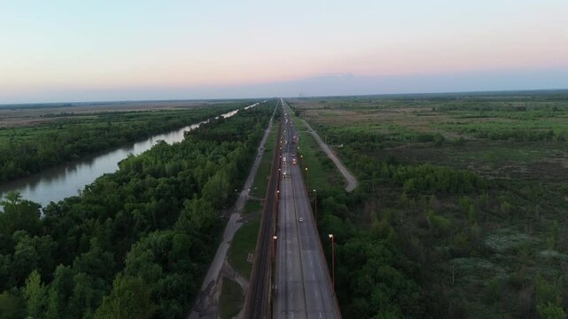 Aerial view of cars driving on Bartolome Mitre Bridge over Parana River Delta at sunset, connecting the cities of Campana and Zarate, Buenos Aires, Argentina