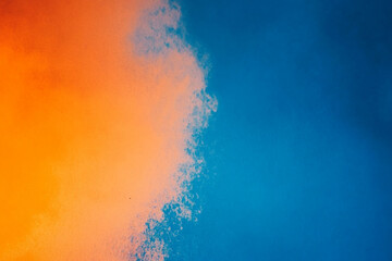 Fototapeta premium Smoke is rising from a blue and orange cloud