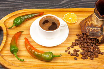 A rustic wooden tray holds a steaming cup of coffee in a white cup, a traditional cezve pot, and...