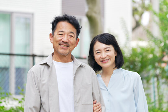 腕を組む中年の夫婦　ポートレート　屋外