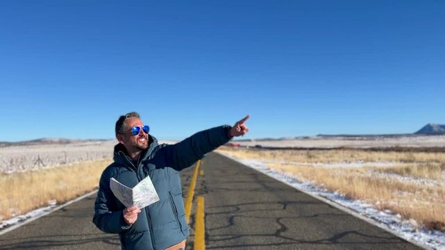 Tourist navigating desert landscape along iconic Route 66, holding map and pointing direction during cross-country road trip through Arizona wilderness