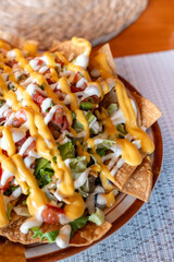 Enjoy delicious loaded nachos topped with colorful toppings and a rich, creamy cheese sauce