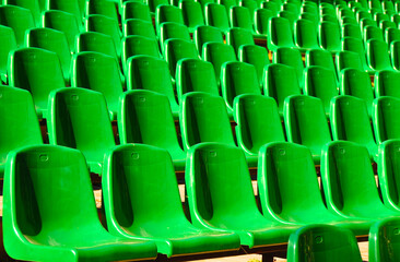 Fototapeta premium rows of vibrant green seats in a stadium, arranged in a neat and orderly pattern