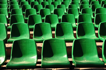  rows of vibrant green seats in a stadium, arranged in a neat and orderly pattern
