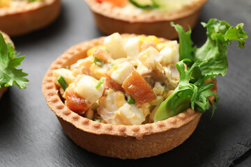 Tartlets with delicious filling on black table, closeup