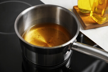 Used cooking oil in saute pan on stove, closeup