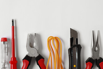 Different electrical tools on light background, flat lay. Space for text