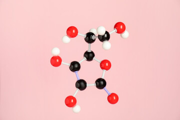 Molecule of vitamin C on pink background. Chemical model
