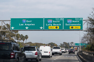 Slow traffic driving below freeway signs on the Santa Monica 10 freeway at the San Diego 405 freeway interchange in Los Angeles.  