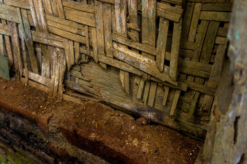Woven wall made of thin dry bamboo, background pattern covered with moss. Woven bamboo.