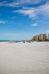 a gorgeous landscape at Clearwater Beach with hotels and palm trees along the beach and people walking in Clearwater Florida USA